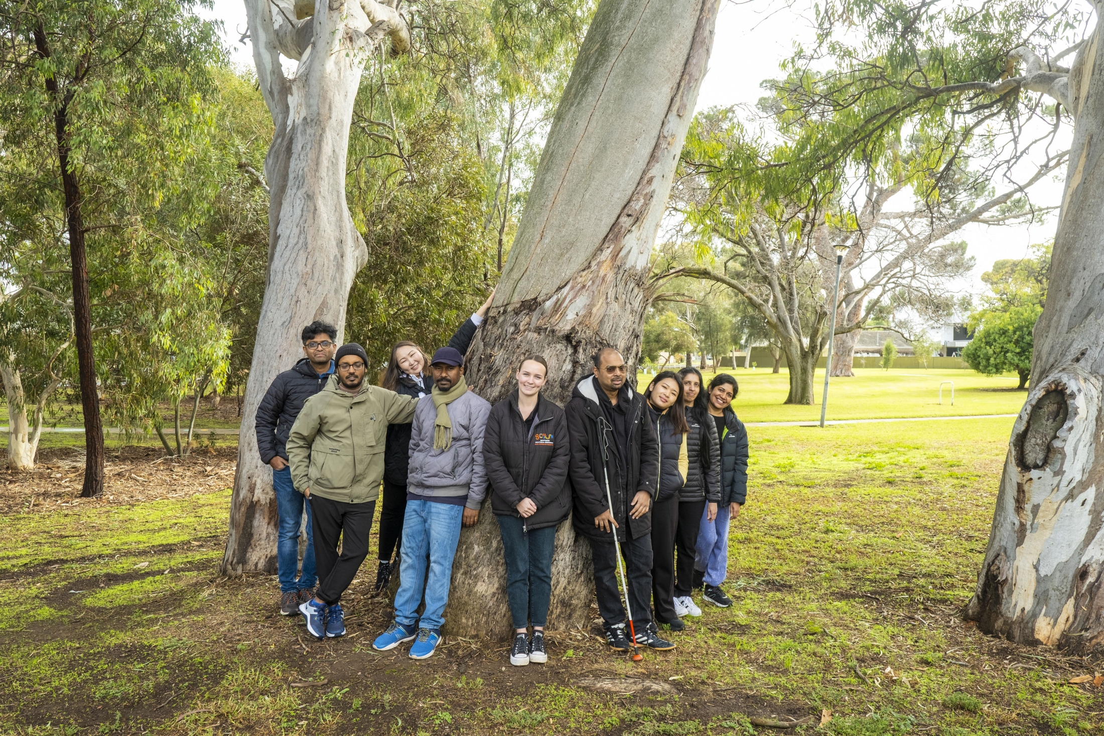 Tuan (fourth from right) with fellow Australia Awards scholars and the tour guide at the Warriparinga Wetlands in Adelaide during a NAIDOC Week engagement event, pictured beside an 800-year-old canoe tree.